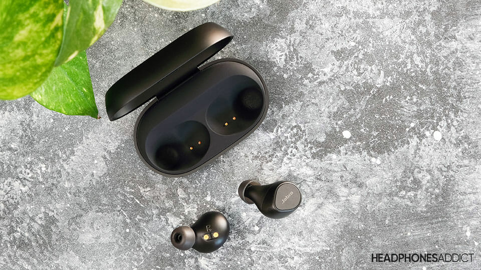 Jabra Elite 7 Pro earbuds and case on concrete surface