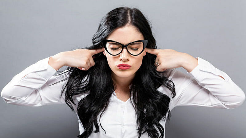 woman plugging ears to reduce noise